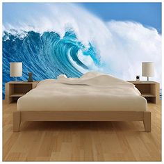 a bed sitting in front of a wall with a large wave coming out of it