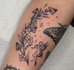 a black and white photo of some tattoos on someone's arm with flowers and butterflies