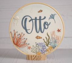 an embroidered sign with the word cto on it, surrounded by fish and corals