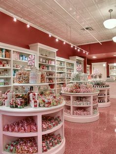 a store filled with lots of different types of candy and candies in white shelves