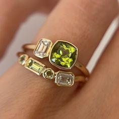 One of our favorite pieces from our August birthstone capsule, this toi et moi and tracer band set features bezel-set peridot and diamonds on 14k yellow gold. The 1.10ct cushion peridot with strong yellowish-green hues is complemented by a .23ct emerald diamond. The mixed gemstone shapes on the tracer band add a touch of playfulness to this versatile and modern piece. Wear these rings together or style them separately. Please note resizing this ring adds an extra 7-10 days for delivery. Mixed Gemstone Rings, Yellow Gold Peridot Jewelry With Emerald Cut, Stackable Yellow Gold Peridot Jewelry, Yellow Gold Peridot Stackable Rings For Anniversary, Gemstone Shapes, Yellowish Green, August Birthstone, Green Hues, August Birth Stone