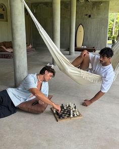 two men playing chess in a hammock