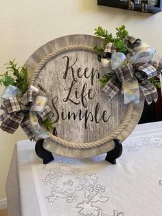 a wooden sign that says keep life simple on top of a table with flowers and greenery