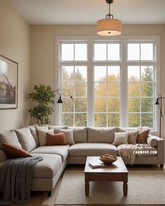 a living room filled with furniture and large windows