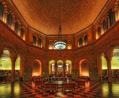 the interior of a library with checkered flooring and arched windows on both sides