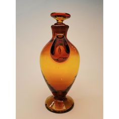 a brown and yellow glass vase sitting on top of a table