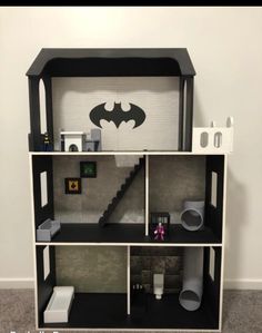 a dollhouse with a batman symbol on the wall