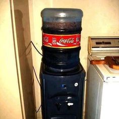 a coke machine sitting next to a refrigerator