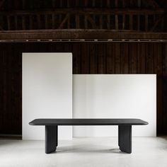 a black table in an empty room with white walls