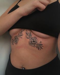 a woman's stomach with flowers and leaves tattooed on the side by her belly