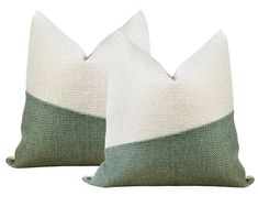 two green and white pillows sitting next to each other