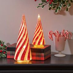 two lighted christmas trees sitting on top of a table