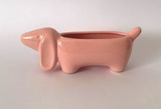 a pink elephant planter sitting on top of a white table