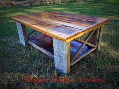 a wooden table sitting on top of a lush green field