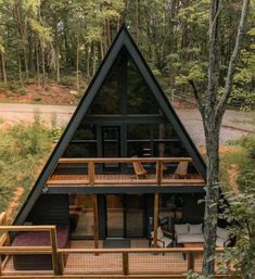 a - frame cabin in the woods surrounded by trees