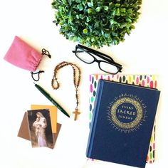 a table topped with books and glasses next to a potted plant