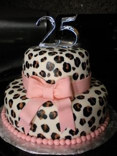 a birthday cake decorated with leopard print and pink ribbon, featuring the number twenty five