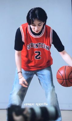 a young man holding a basketball in his right hand