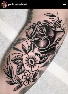 a black and white tattoo with an animal on it's arm, surrounded by flowers