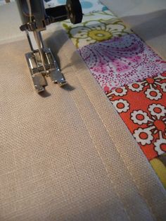 a close up of a sewing machine on a piece of fabric that is being sewn