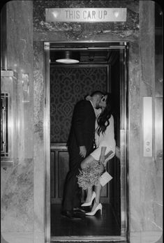 a man and woman kissing in an elevator while holding each other's leg up