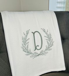 a monogrammed pillow on a couch with the letter d in it's center