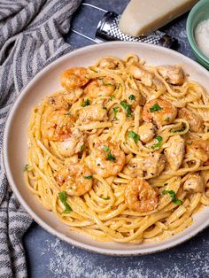 a plate of pasta with shrimp and parmesan cheese