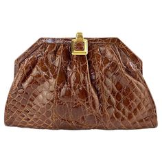 Presenting a stunning saddle brown Gucci crocodile convertible crossbody. This beautiful bag is constructed entirely of genuine glossy crocodile leather and is finished with gold accent hardware. From the Spring/Summer 1987 collection, this bag was prominently featured in a Gucci advertisement that year. The bag can be a clutch or crossbody with a convertible gold chain. This classic bag is in like-new condition and is the perfect addition to any personal wardrobe or collection. Approximate meas Gucci Advertisement, Expensive Bag, Designer Clutch Bags, Popular Handbags, Large Clutch, Plush Bags, Crocodile Bags, Gucci Bamboo, Gold Bag