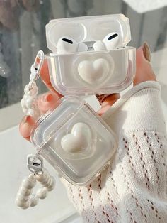 a person holding two clear plastic cases with white hearts on the top and one in the middle