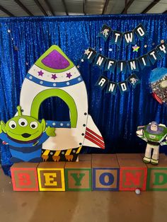 two toy rockets are sitting on blocks in front of a backdrop that says, beyond