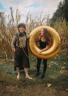 two people standing next to each other holding an inflatable tube