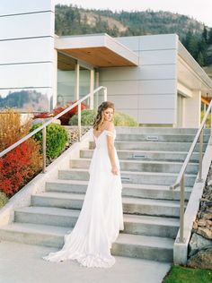 a woman in a white dress standing on some steps