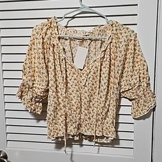 Beautiful Floral Top For Spring, Summer Or Fall. Ruffle Sleeves And Slight Ruffle On The Hem. Elastic On Sleeves And Hem Where Ruffle Is Located. Ruffle Along Neckline, As Well. Tie On Neckline. It Is A Cream Backgroud With Small Pink Flowers And Small Green Leaves. I Bought It At A Local Boutique. Never Worn And Still Has The Tag From When I Bought It. Summer Feminine V-neck Peasant Top, Feminine Summer Peasant Top With V-neck, Feminine Summer Peasant Top V-neck, Feminine V-neck Peasant Top For Summer, Summer V-neck Peasant Top With Ruffles, Summer Peasant Top With Ruffles And V-neck, V-neck Peasant Top With Ruffles For Summer, Feminine Summer Peasant Top With Floral Print, Feminine Floral Print Peasant Top For Summer