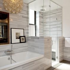 a bathroom with a chandelier hanging from the ceiling and a bathtub next to it