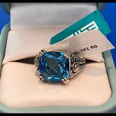 a blue stone ring sitting in a box with a tag on it's side