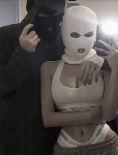 a woman wearing a white mask standing next to a man