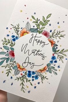 a hand holding up a card with the words happy mother's day on it