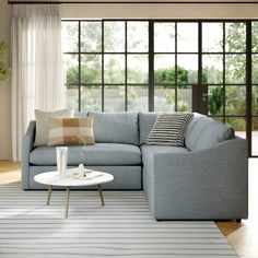 a living room with a sectional couch and coffee table