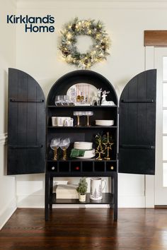 a black book shelf with christmas decorations on top