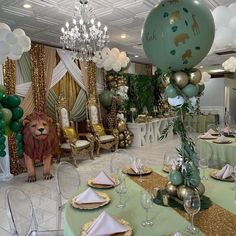 a room filled with lots of green and gold balloons in the shape of animals on top of tables