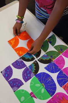 a person cutting out paper with scissors on a table