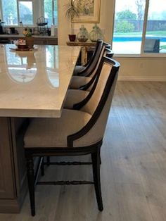 a kitchen island with six chairs in front of it and an open door leading to the back yard