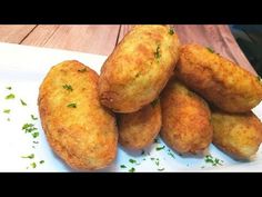 some fried food on a white plate with parsley sprinkled around the edges