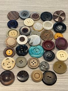 a collection of buttons sitting on top of a wooden table