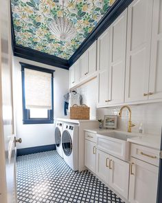 a washer and dryer in a white kitchen with blue accents on the ceiling