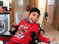 a young boy sitting in a wheel chair