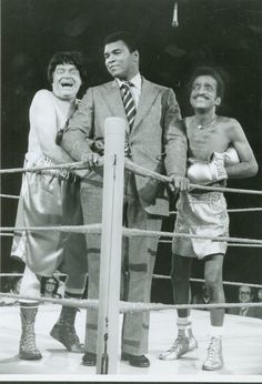 three men standing next to each other in a boxing ring