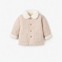 Our soft, cushiony quilted jacket is made from the softest materials and features a stylish, fuzzy vegan sherpa collar for extra warmth during those cold winter months. Pair with one of our coordinating cable knit baby hats or fun pom pom baby hats to complete the look.

Shell: 100% Organic Cotton, Collar: 100% Polyester Vegan Sherpa
Features quilted shell with wooden button closures
Machine wash warm, do not bleach, tumble dry normal, medium iron, do not dry clean Cotton Cable Knit Outerwear For Cold Weather, Cable Knit Cotton Outerwear For Cold Weather, Cable Knit Outerwear For Winter, Winter Cable Knit Outerwear For Cold Weather, Winter White Cable Knit Outerwear, Cozy Cotton Outerwear With Fleece Lining, Winter Cotton Quilted Jacket For Cold Weather, Winter Quilted Cotton Jacket For Cold Weather, Cream Cotton Cable Knit Outerwear