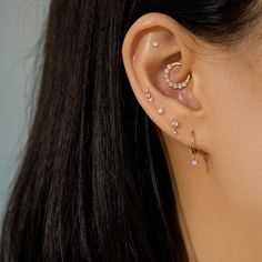 a close up of a person wearing an ear piercing with pearls on it's sides