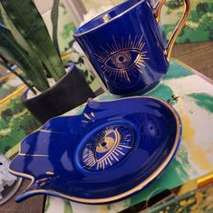 a blue cup and saucer sitting on top of a table